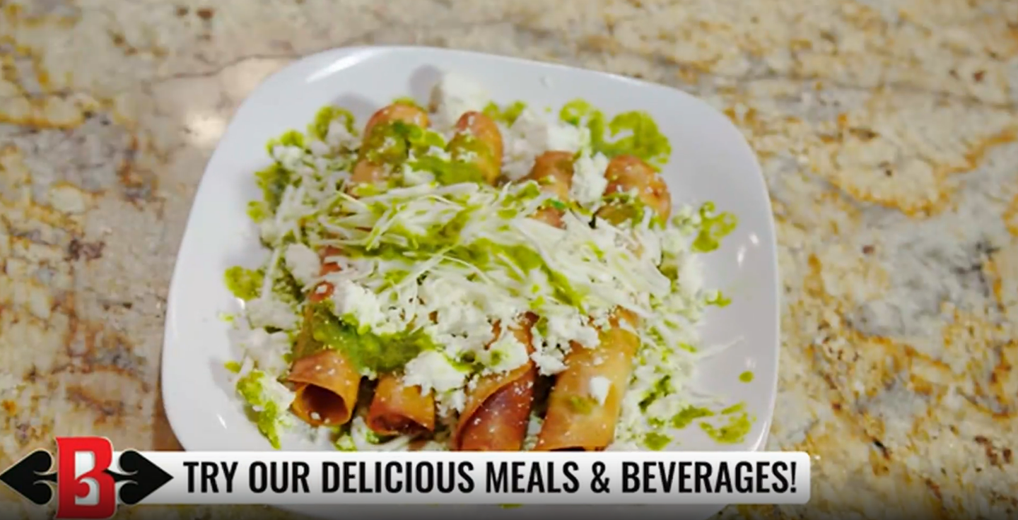 Close-up of a taco topped with shredded cheese on a white plate, with a promo banner at the bottom.