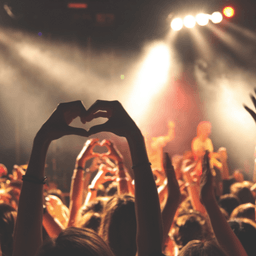A crowd of people making a heart shape with their hands