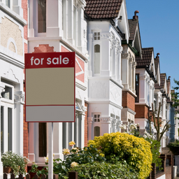 A for sale sign in front of a row of houses