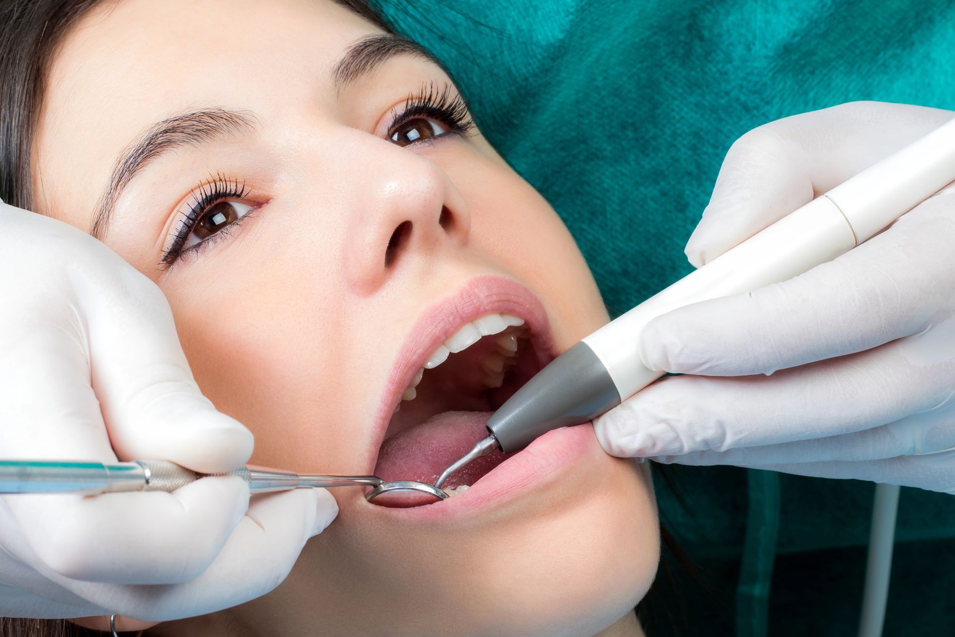 Un dentista in camice e guanti esegue un intervento di impianto dentale su un modello di mandibola umana in una clinica.