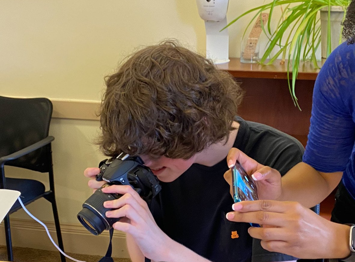 Andrew taking photos with camera and Rolinda taking photo with mobile phone.