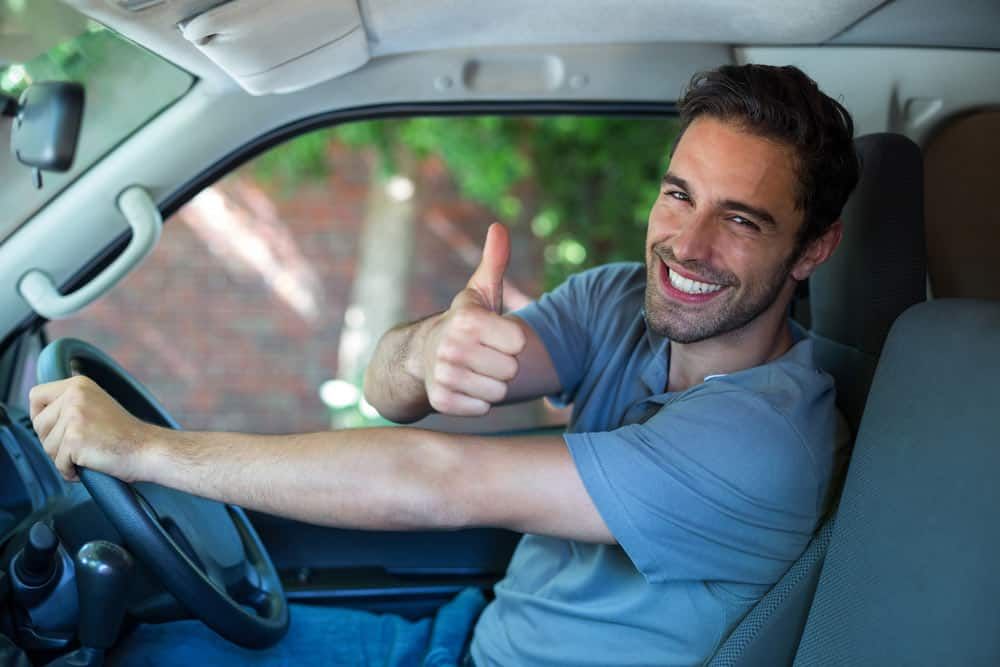 Man Smiling, Giving Thumbs Up While Driving a Car — All Pro Locksmiths In Port Macquarie, NSW