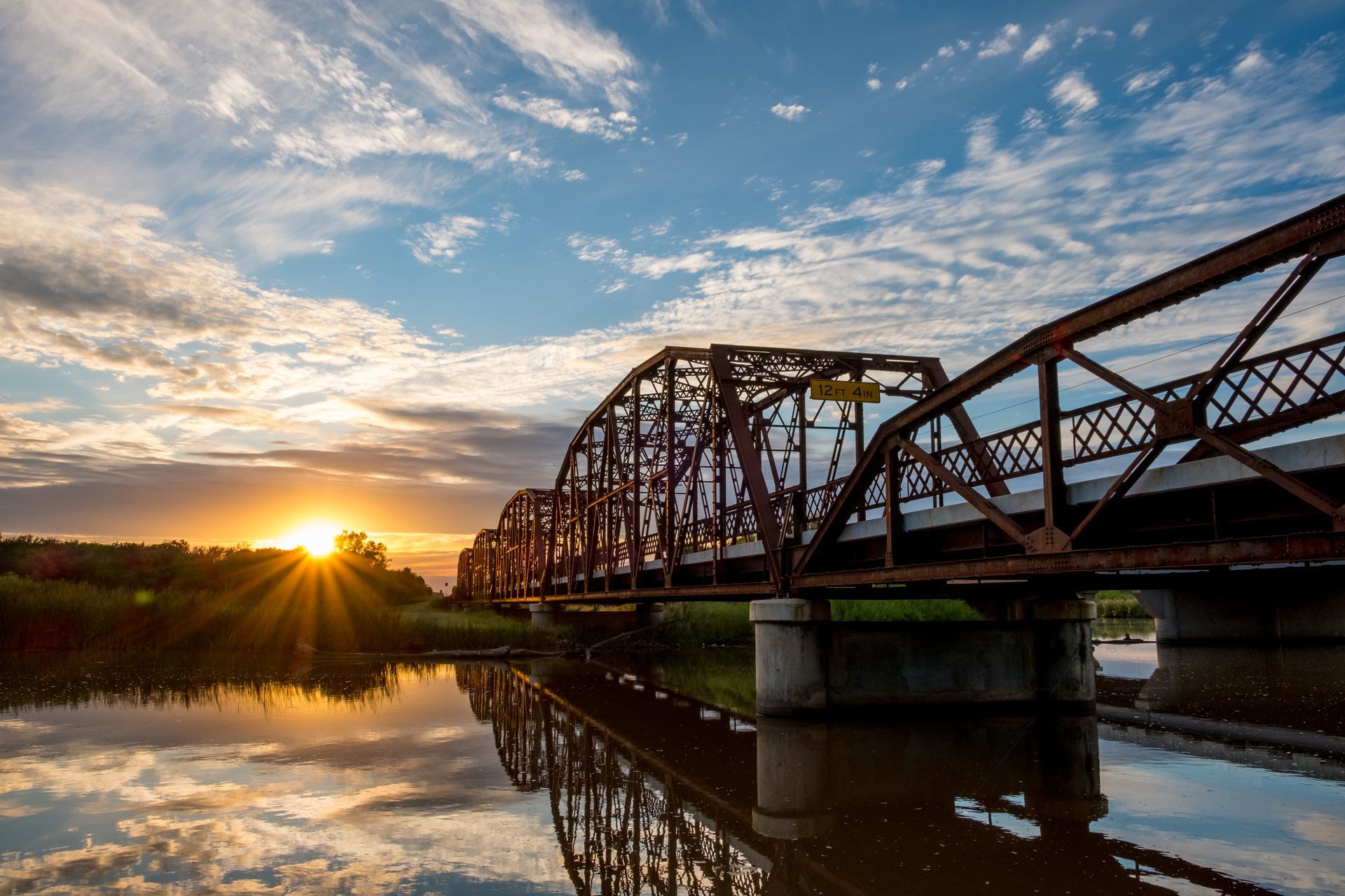 Stock photo of a bridge over water at sunset