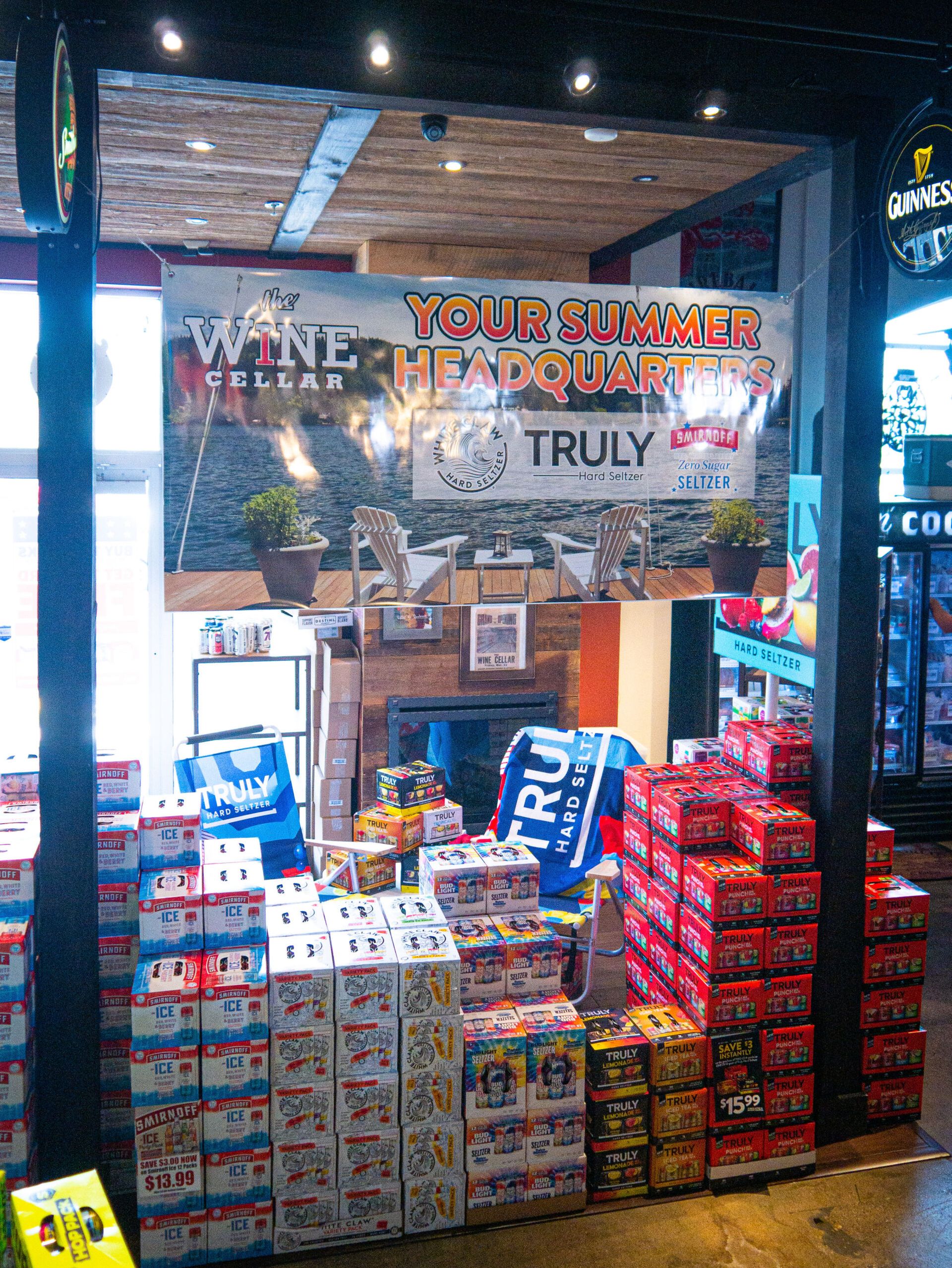 Wine and water shop entrance with stacked bottled drinks and TRULY signage