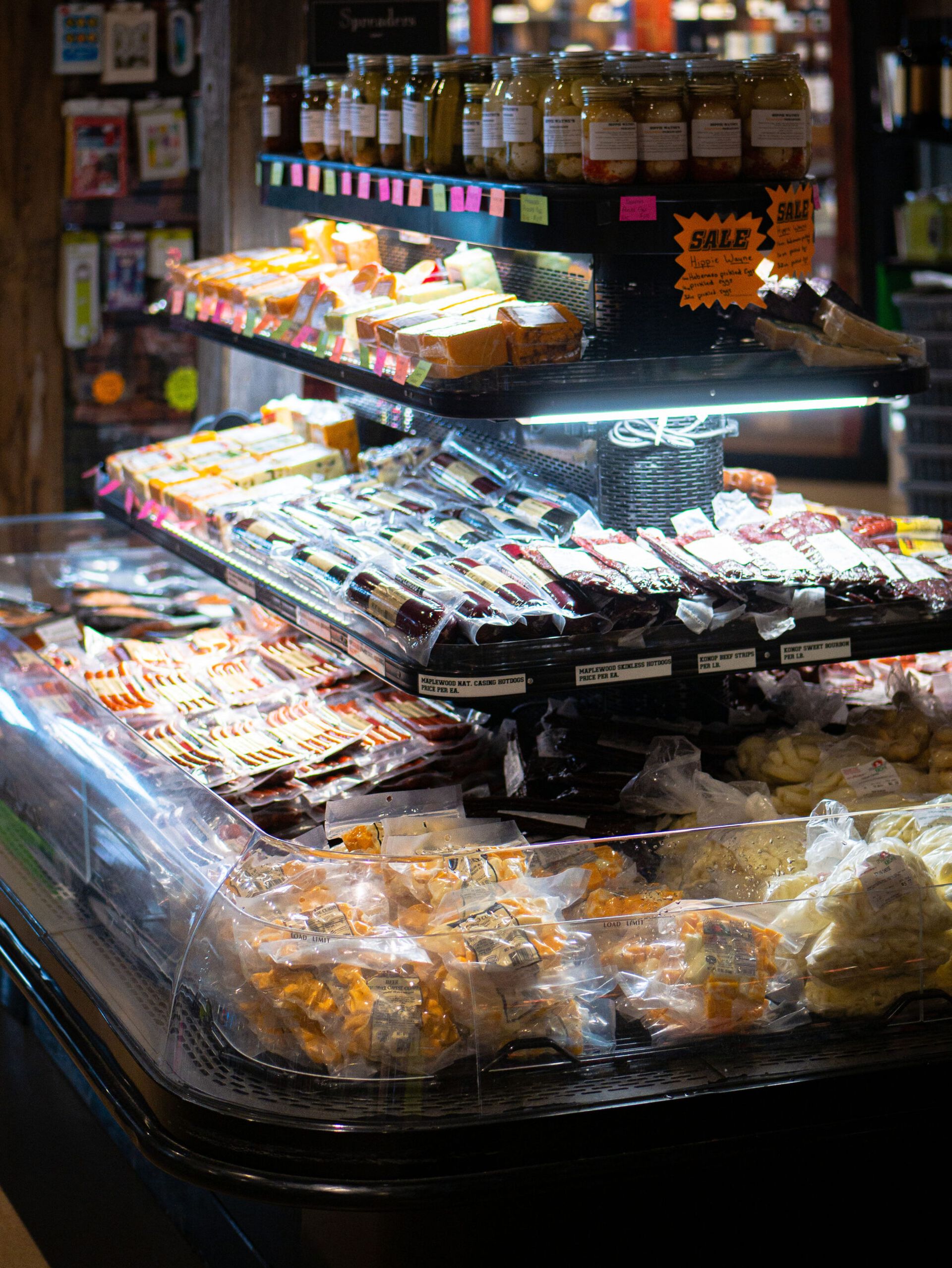 Assorted packaged pastries and snacks displayed on a bakery counter under warm lights