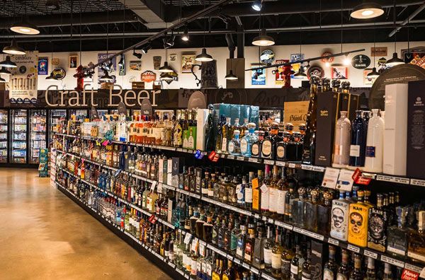 Craft beer aisle in a liquor store with rows of bottles and shelves under bright lights