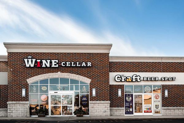 Wine Cellar and Craft Beer Shop storefront with brick facade and glass doors under a blue sky