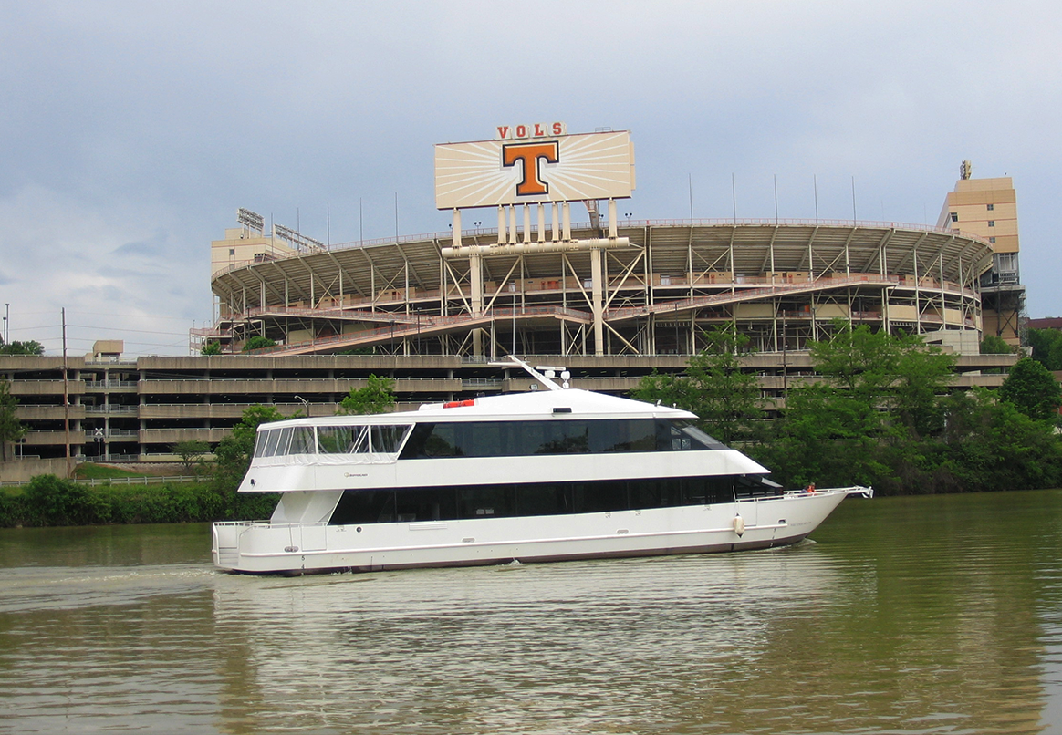 White boat on river, Neyland Stadium in background, large 