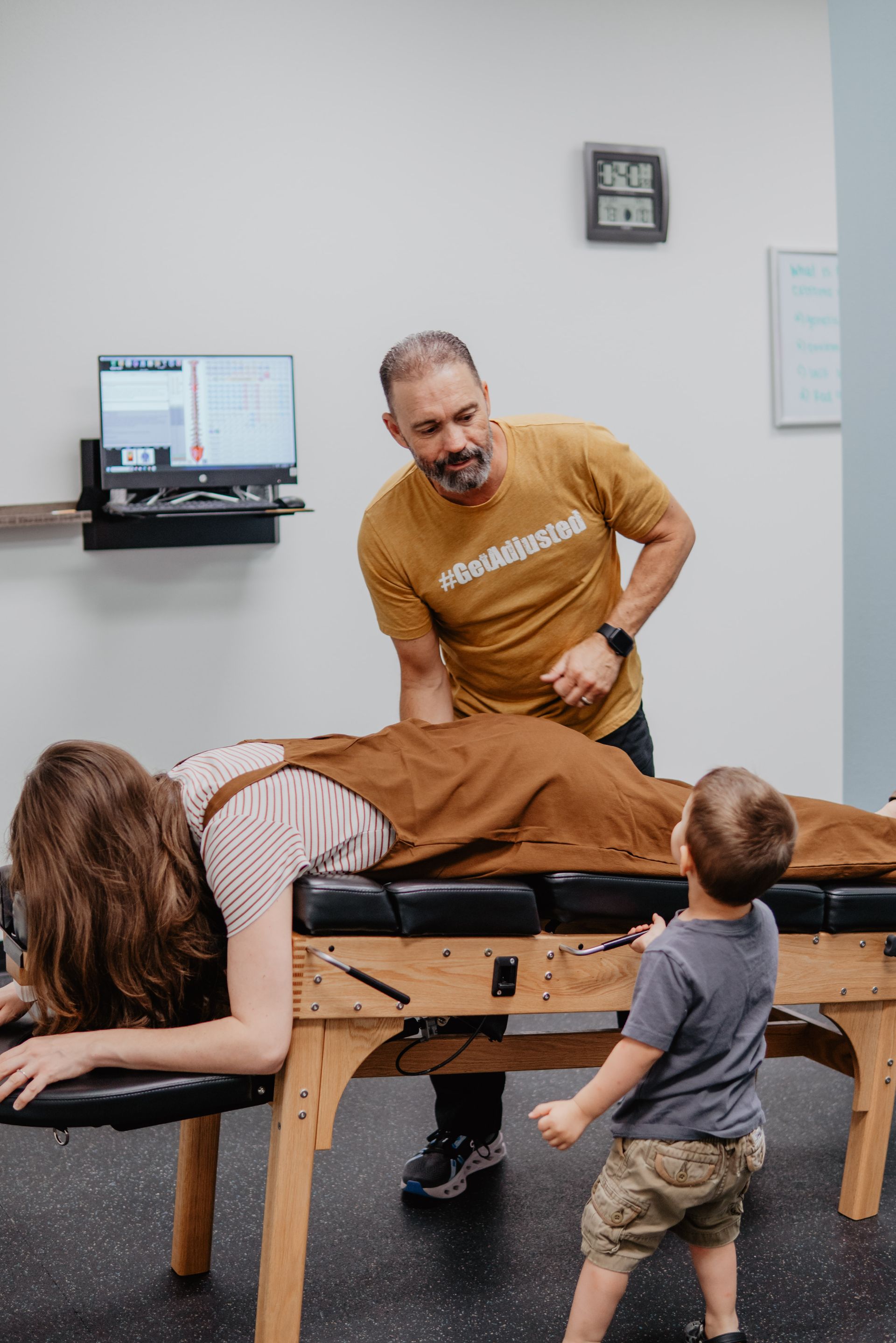 A man is giving a young boy a massage on a table.