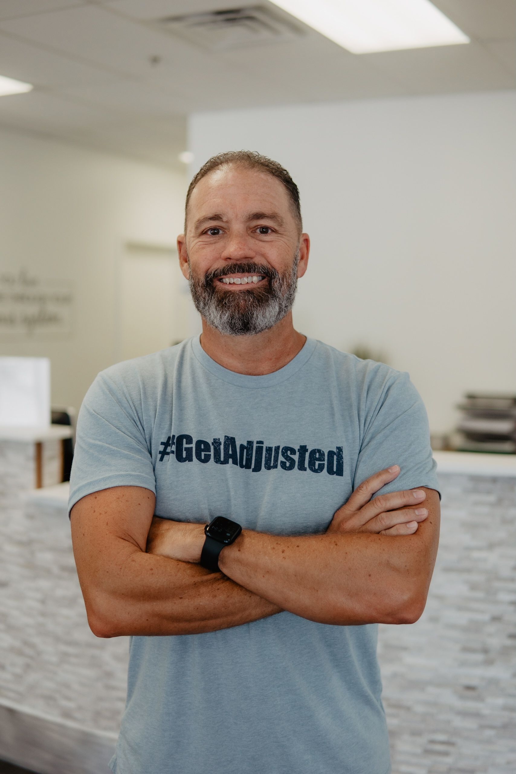 A man with a beard is wearing a t-shirt that says `` get adjusted ''.