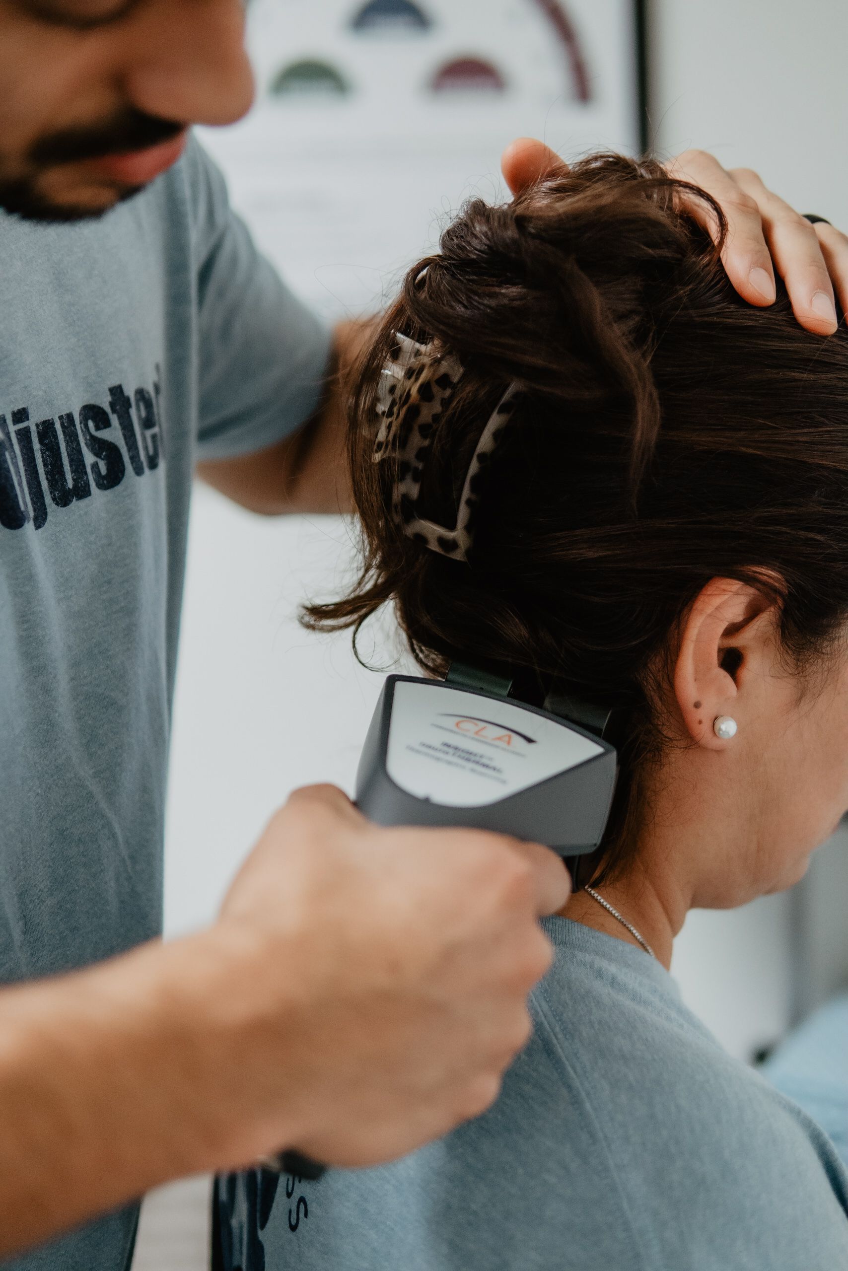 A man is cutting a woman 's hair with a trimmer.