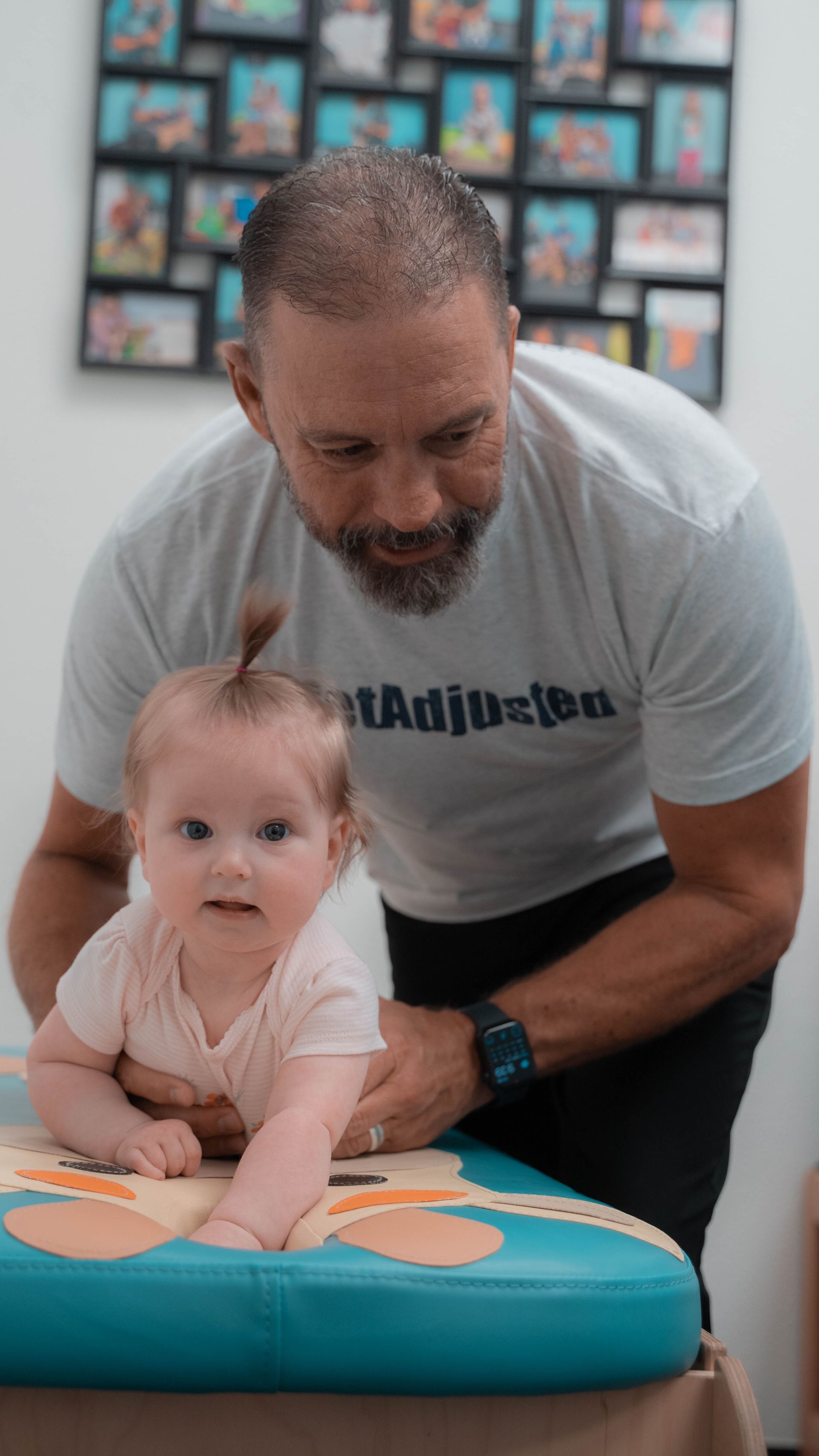 A man is playing with a baby on a table.