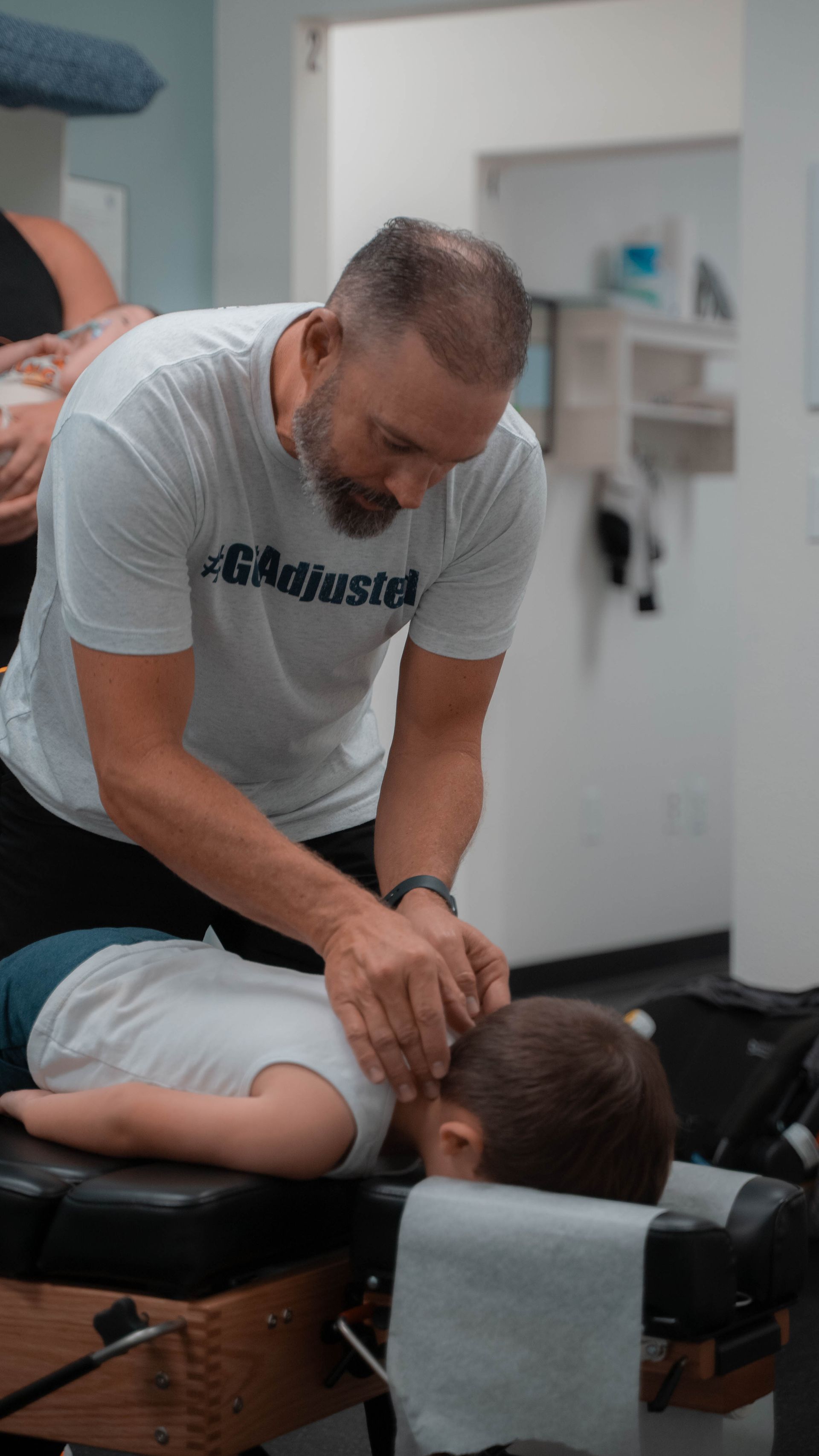 A man is giving a child a massage on a table.