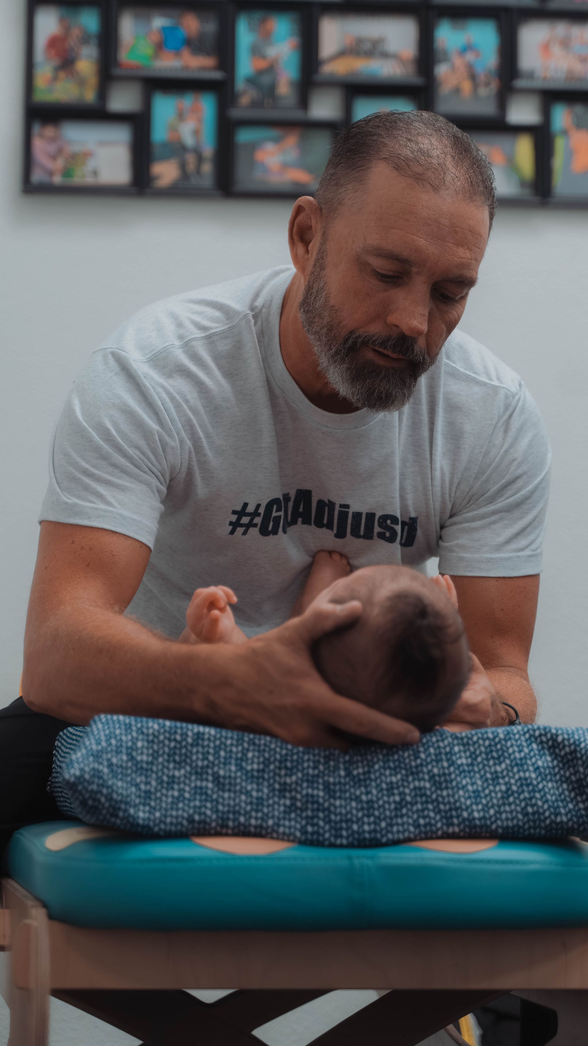 A man is giving a baby a massage on a table.