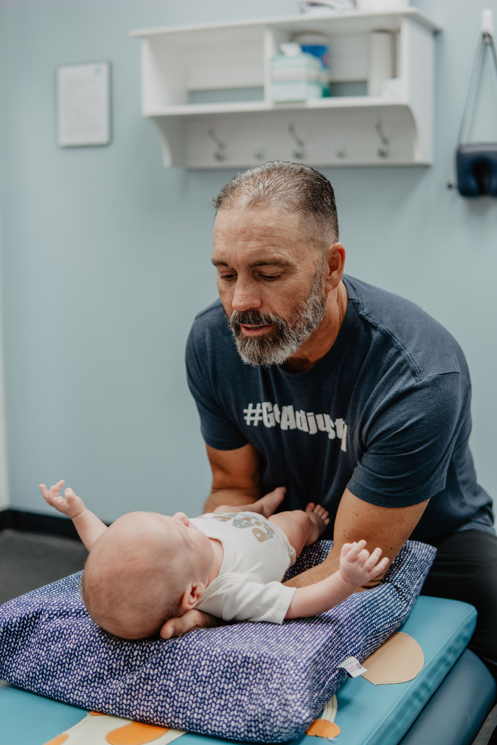 A man is giving a child a massage on a table.