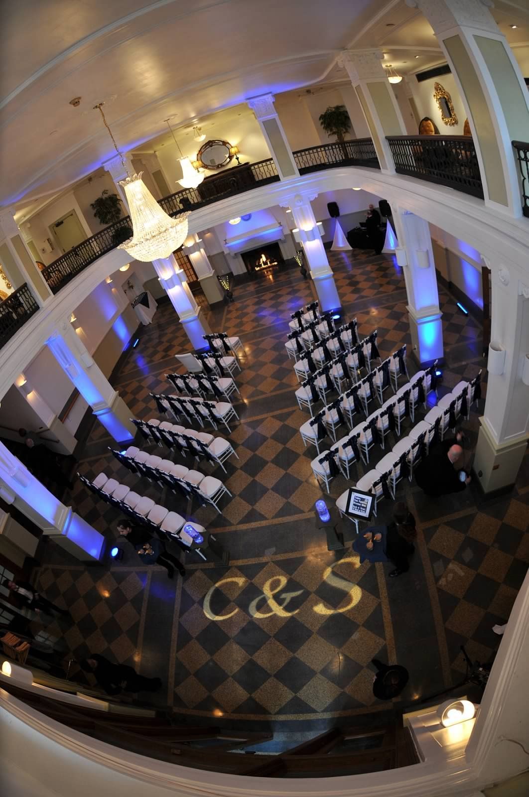 Wedding ceremony setup: Rows of chairs face an altar, illuminated with blue lights. 