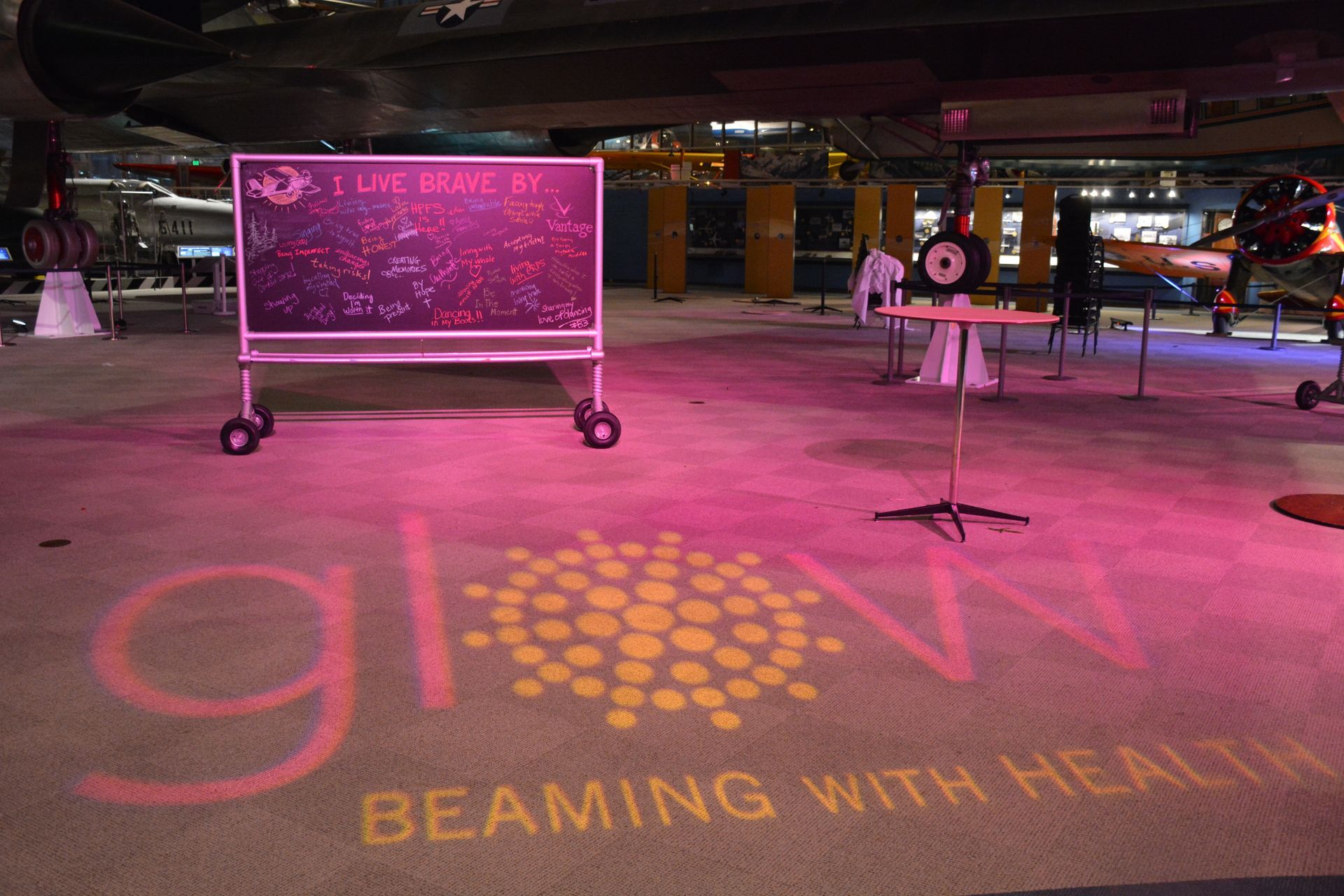 Pink-lit event space. Sign reads 