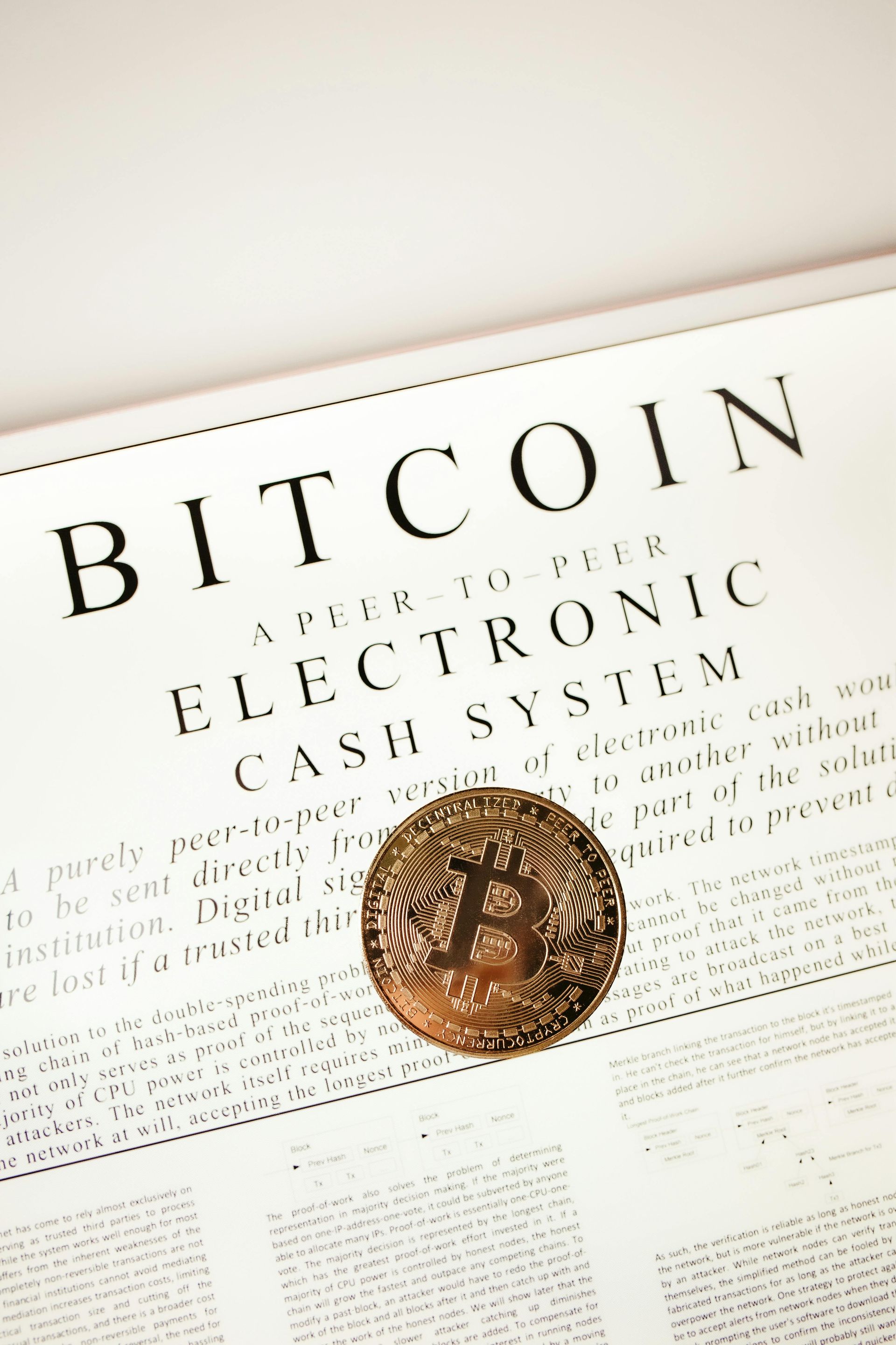 Uma moeda está em cima de um livro intitulado sistema de dinheiro eletrônico bitcoin.