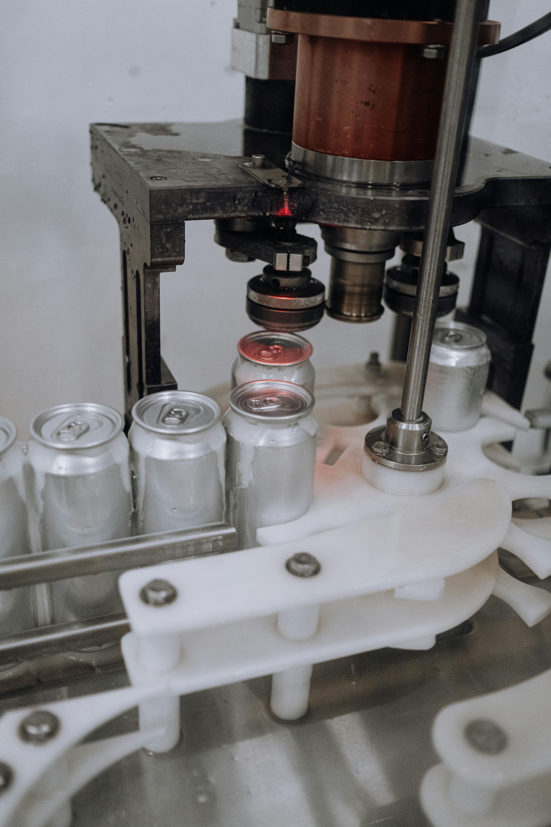 Uma máquina está enchendo uma lata de refrigerante com líquido