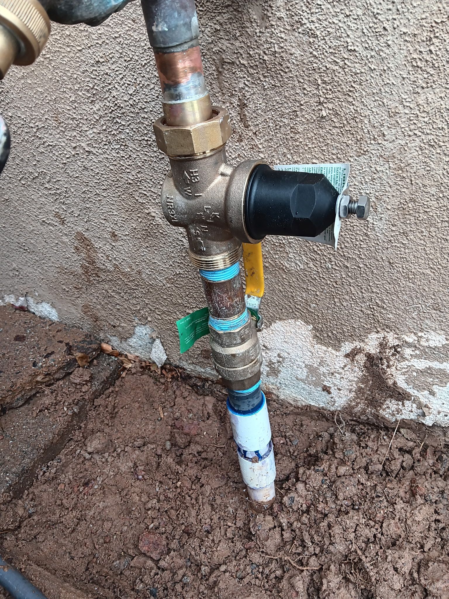 Underground water pipe assembly with valves and fittings emerging from dirt