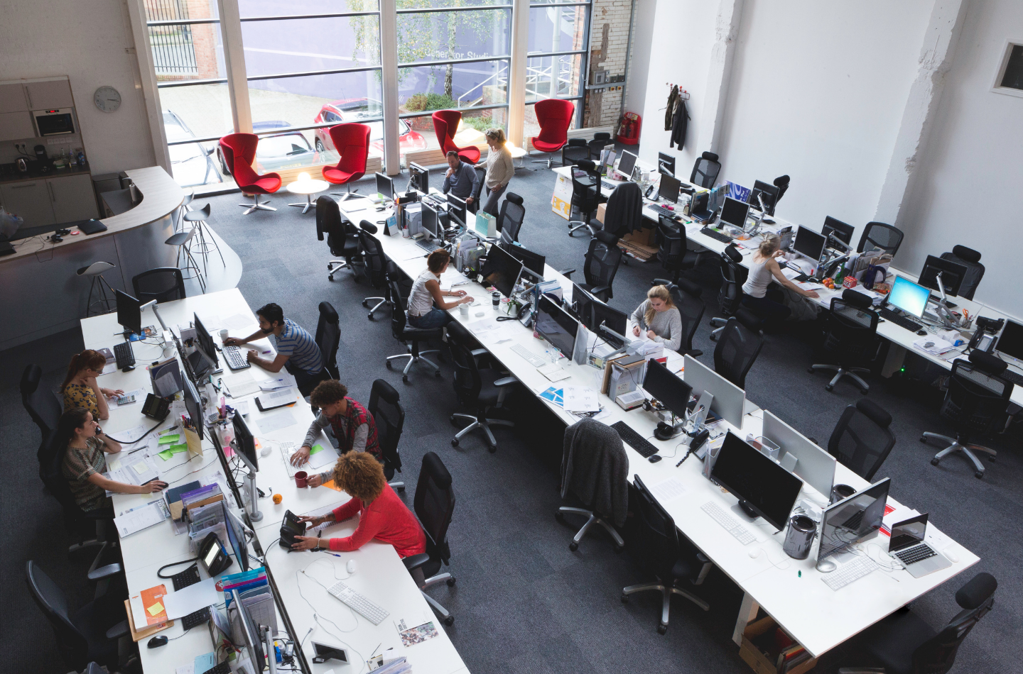 開放式辦公室內進行企業健康講座，多位年輕同仁坐在工作座位上聽講，現場為明亮的大型共享辦公空間，呈現企業員工參與職場健康講座的實際情境。