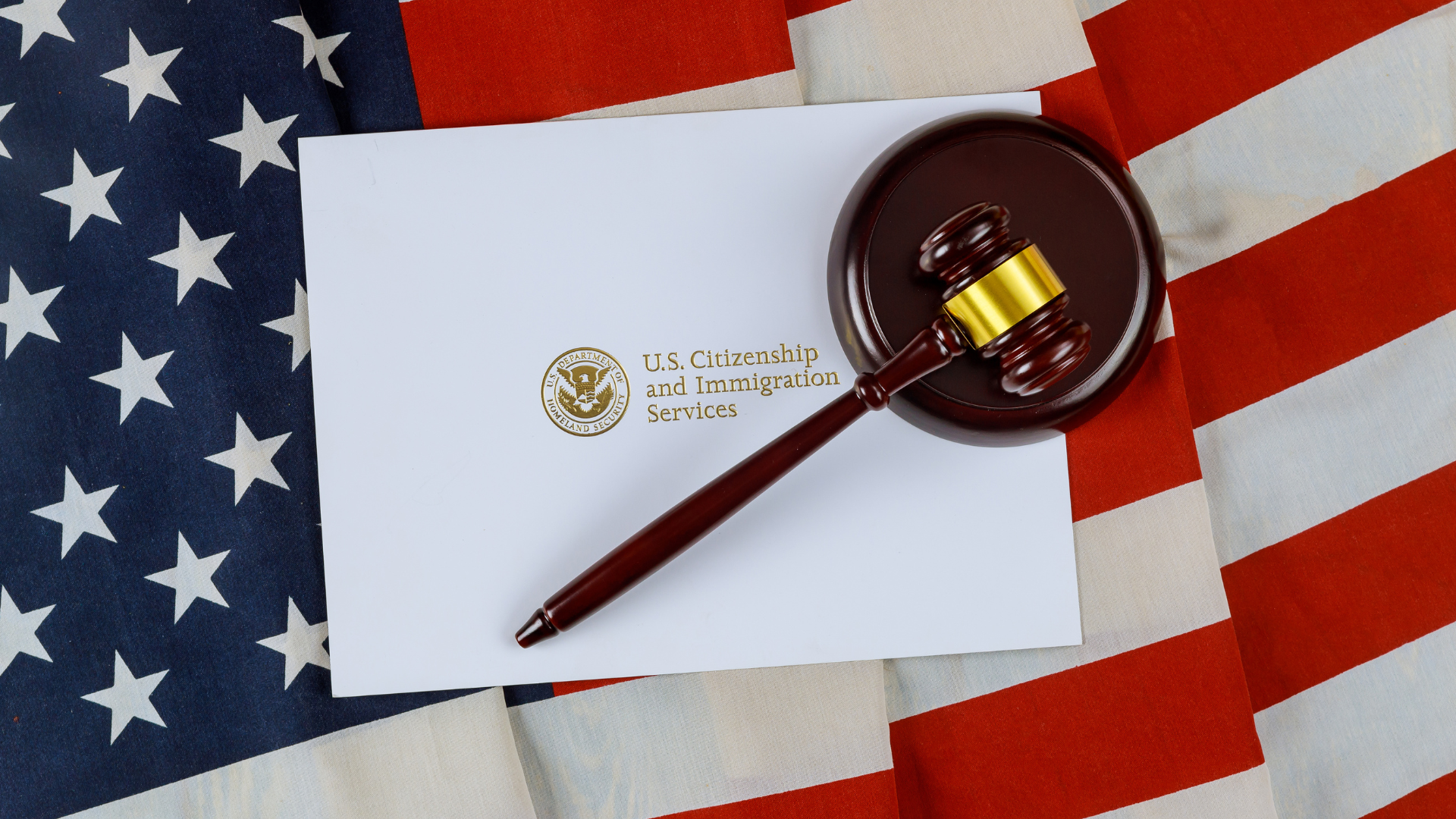 A judge 's gavel is sitting on a piece of paper on top of an american flag.