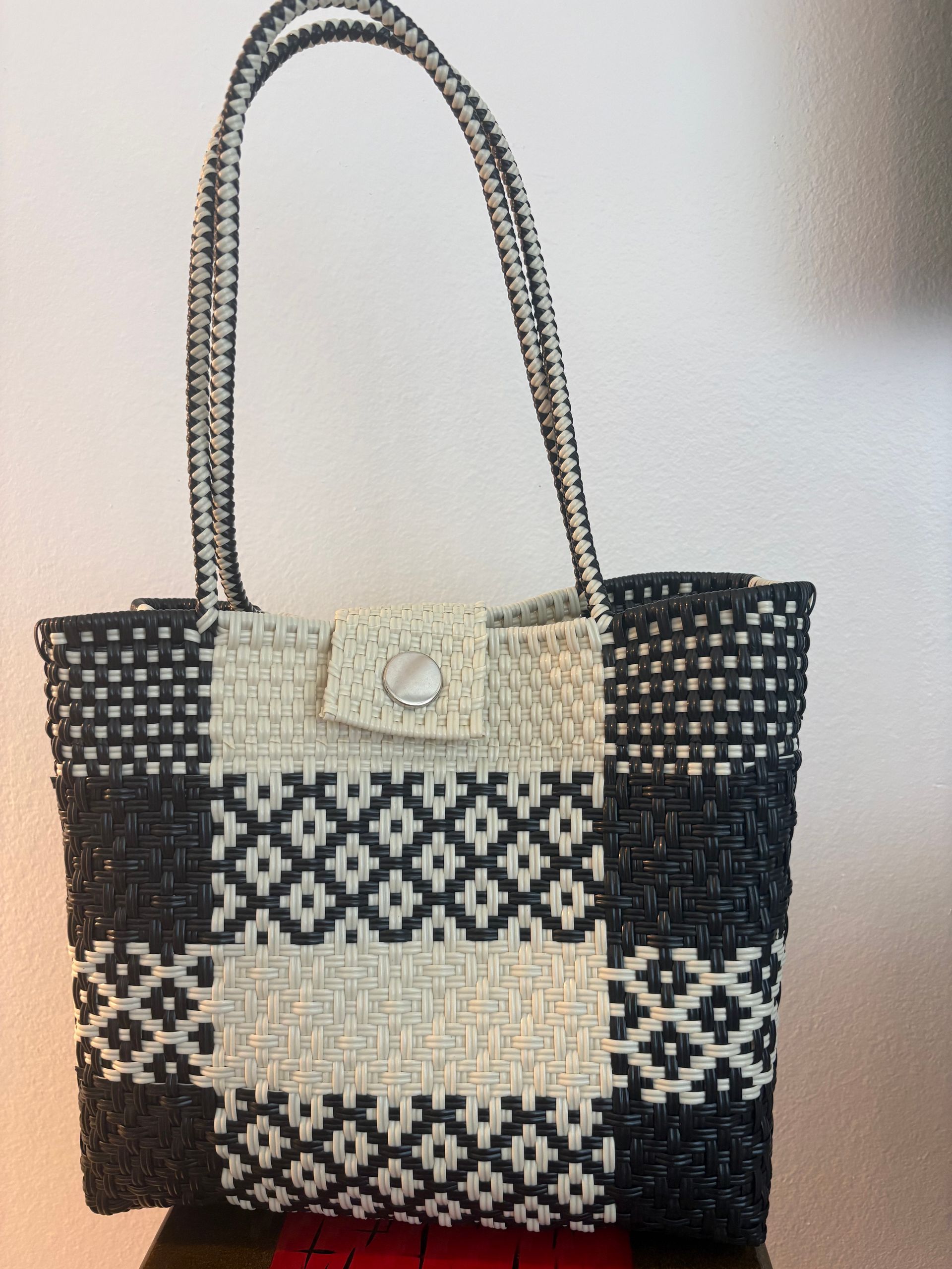 Black-and-cream woven tote bag with long handles and geometric pattern
