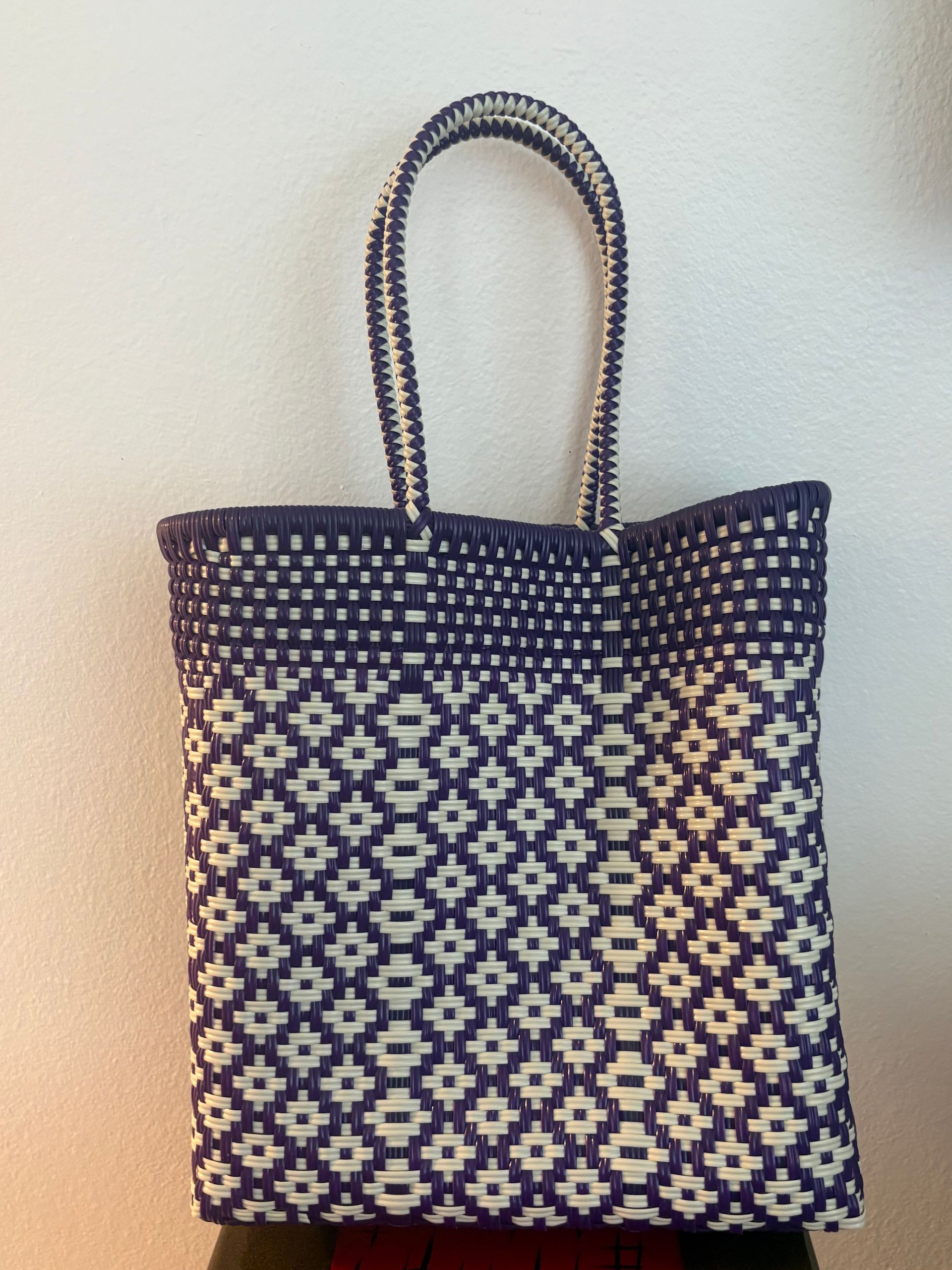 Black-and-white patterned tote bag with two handles on a plain background