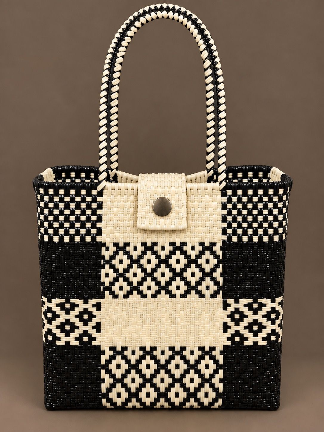 Black and cream woven tote bag with long handles, shown against a plain background