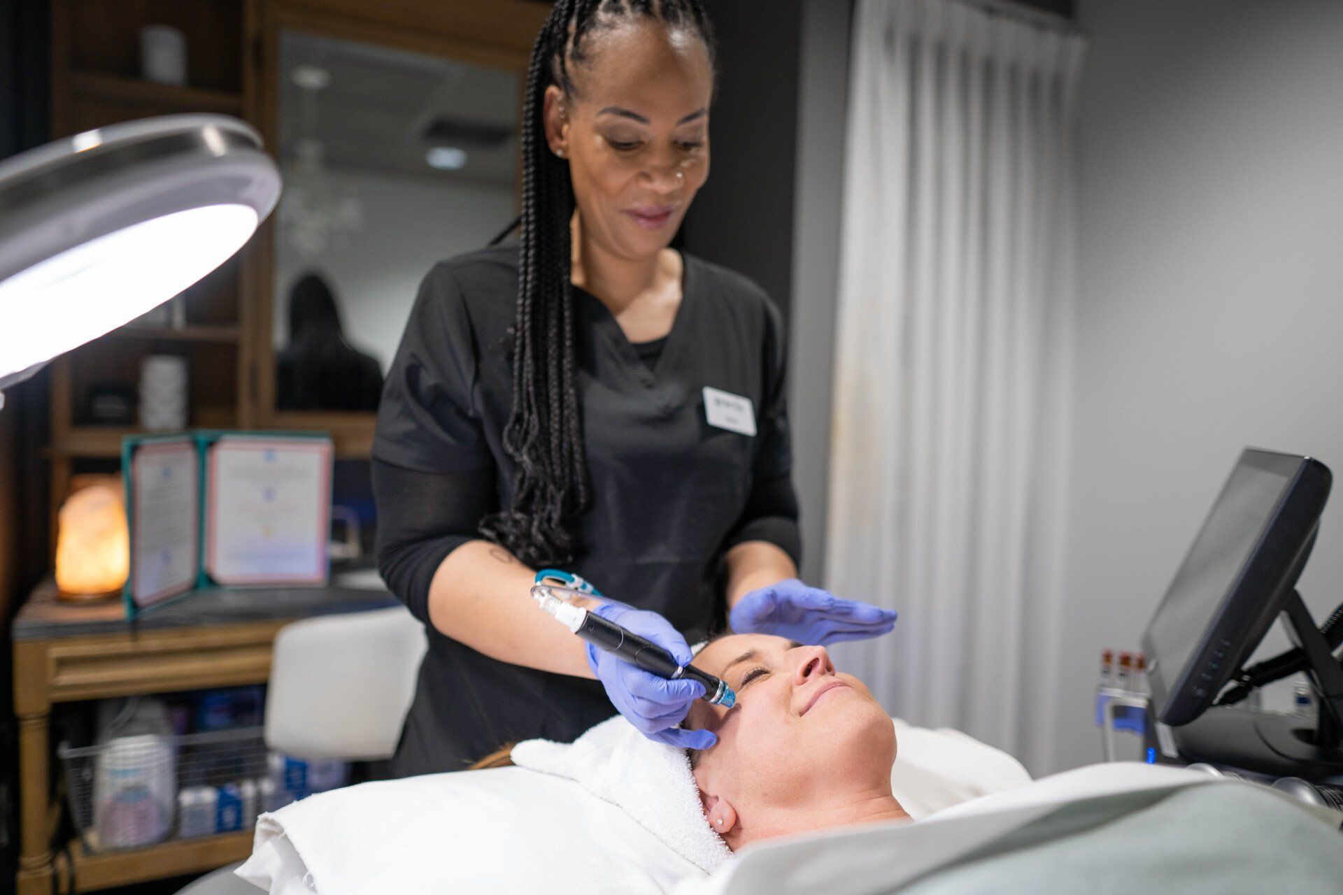 A woman is giving a man a facial treatment in a beauty salon.