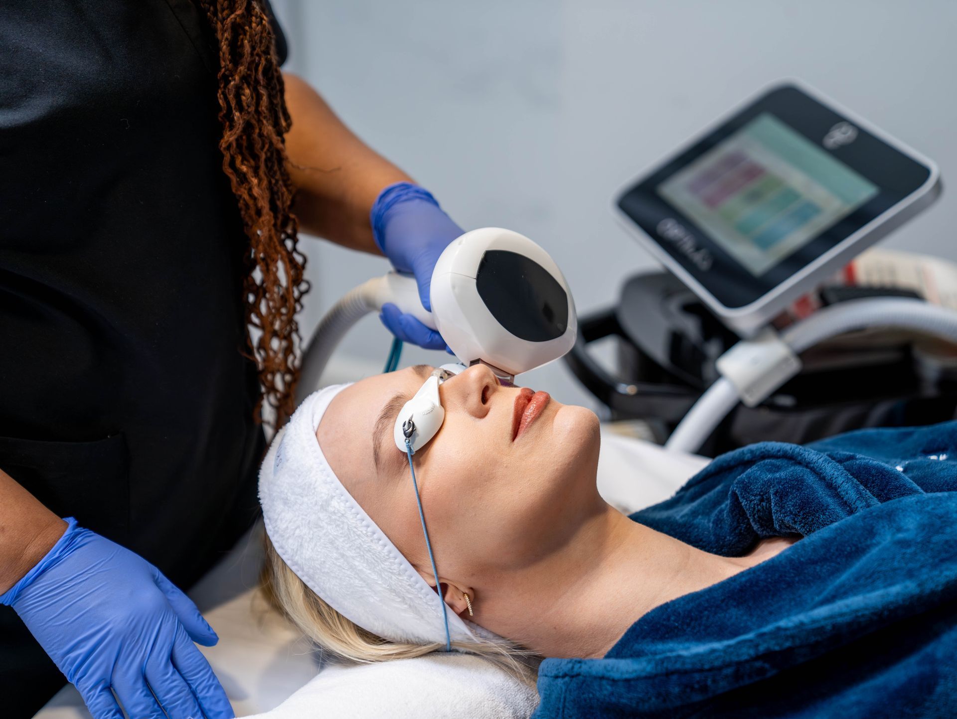 A woman is getting a laser treatment on her face.