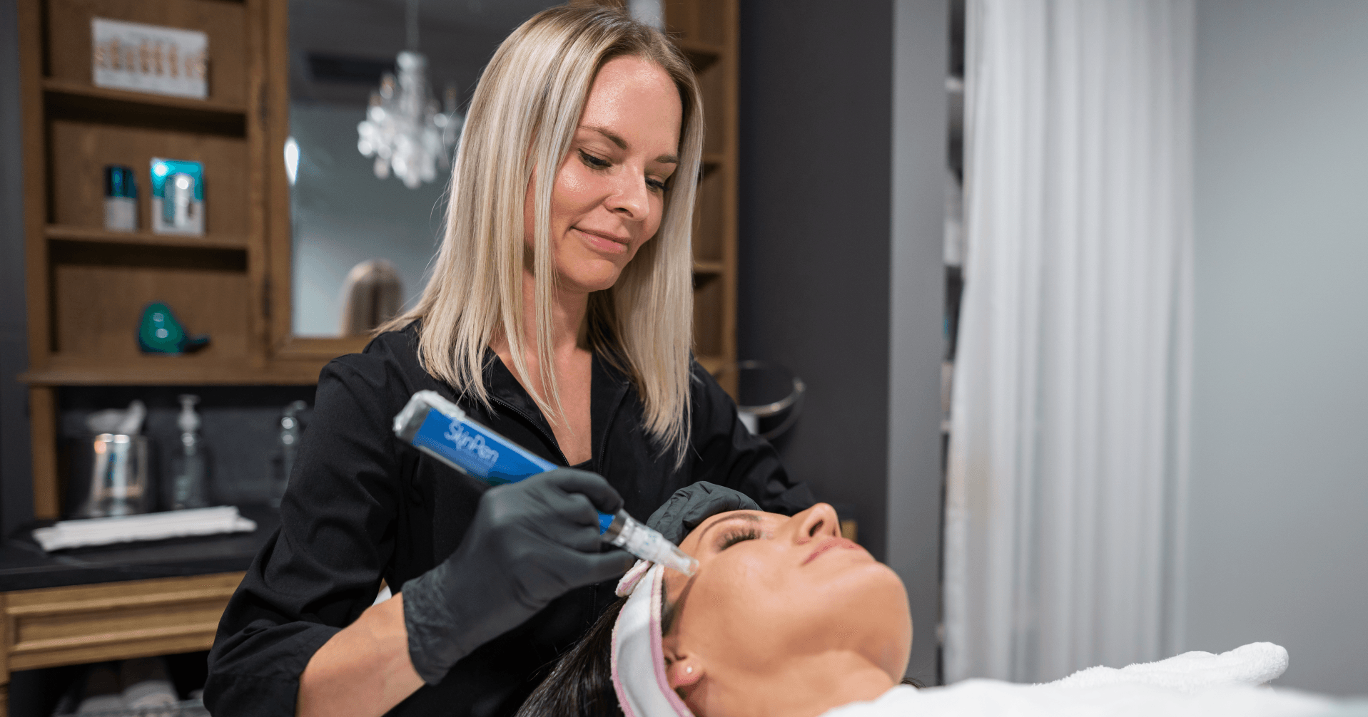 A woman is giving a woman a facial treatment in a salon.