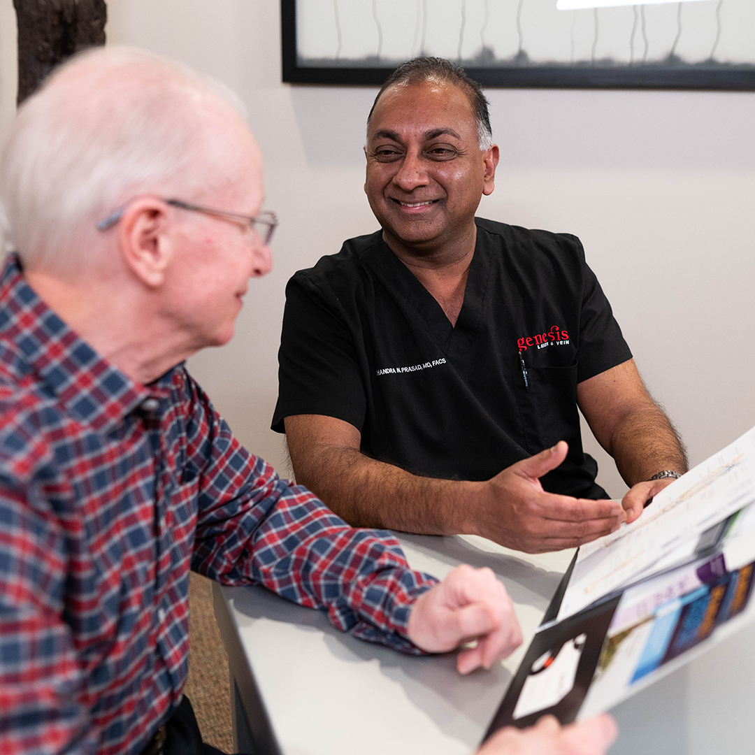 Two men are sitting at a table talking to each other