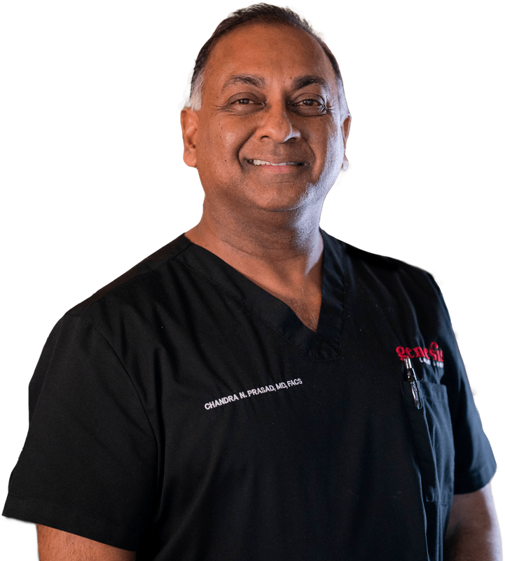 A man in a black scrub is smiling for the camera.