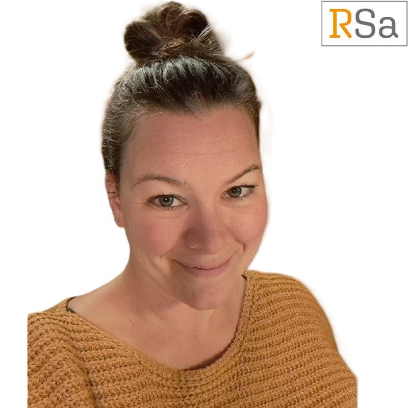 Een vrouw met haar haar in een knotje lacht voor een rsa-logo