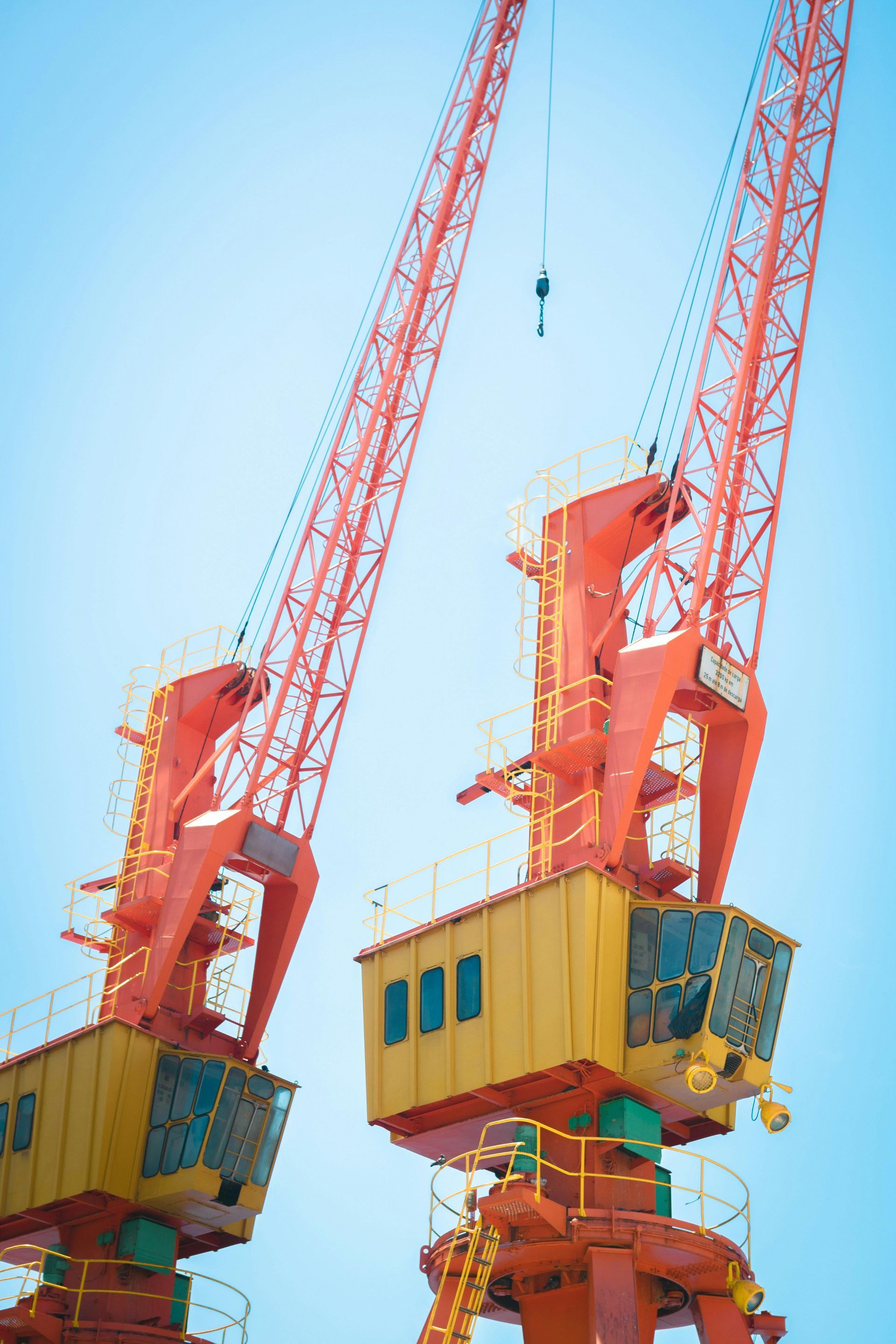 A couple of cranes are sitting next to each other on top of a building.