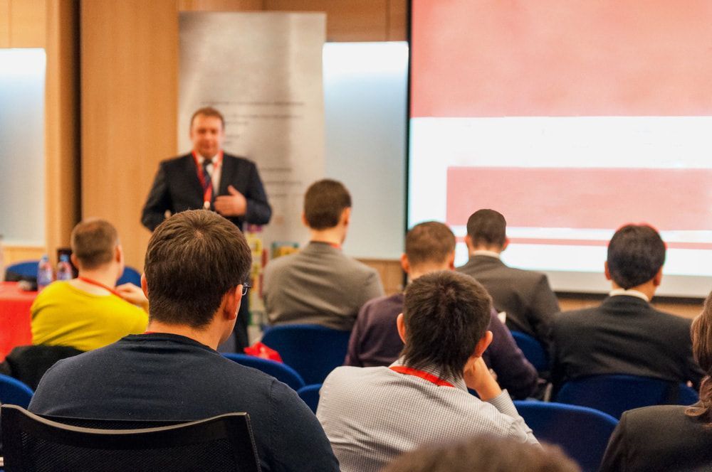 A man is giving a presentation to a group of people in a conference room.