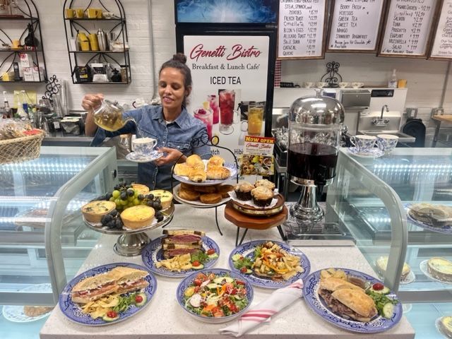 Chef arranging a spread of colorful desserts and pastries at a bakery counter