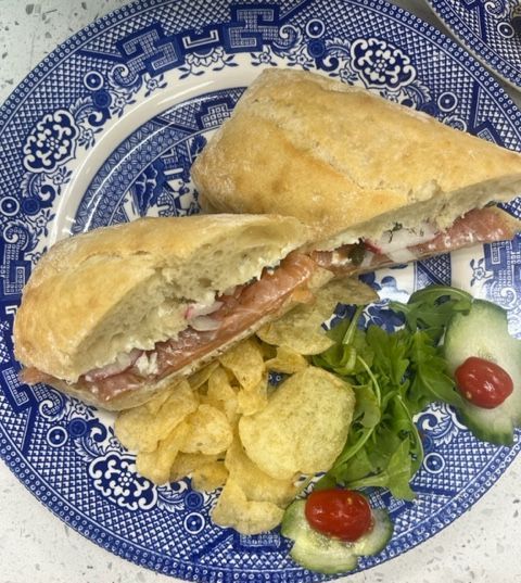 Sandwich halves on a blue-and-white plate with chips and a small green salad