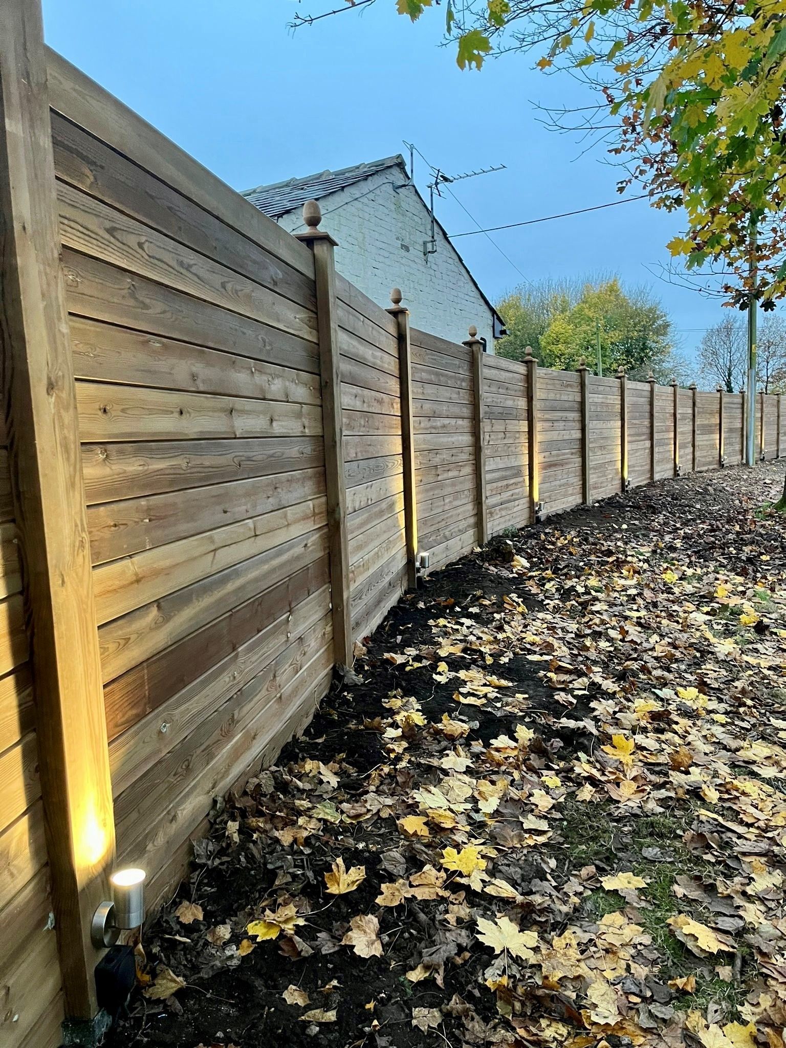 timber cladding with lights at the bottom lighting the fence up