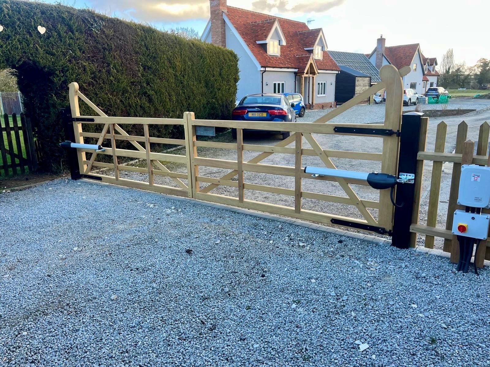 Bespoke farm style Electric Gates with large house in the backround 
