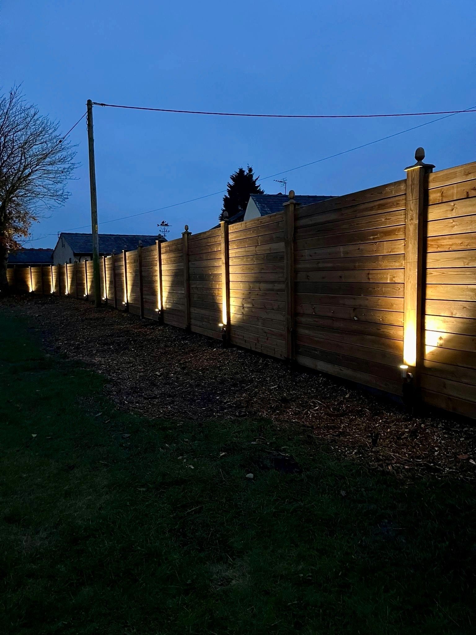 cladded timber fencing with lights lighting them up