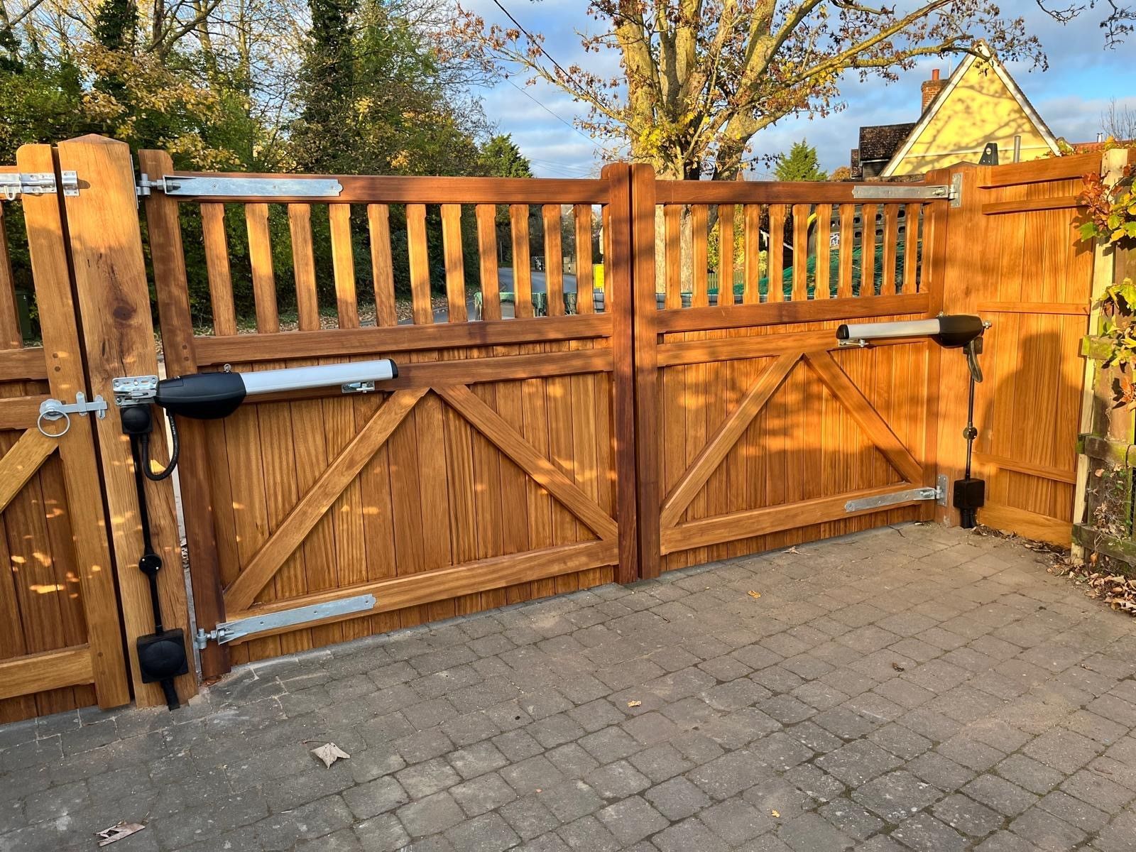 timber square cladded Electric Gate with side footpath gate next to it with trees in background
