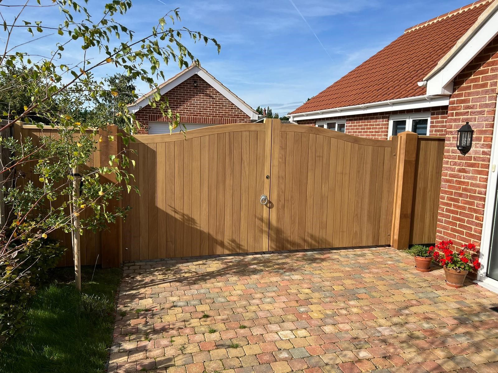 bespoke made timber Electric Gate with bungalow alongside it 

