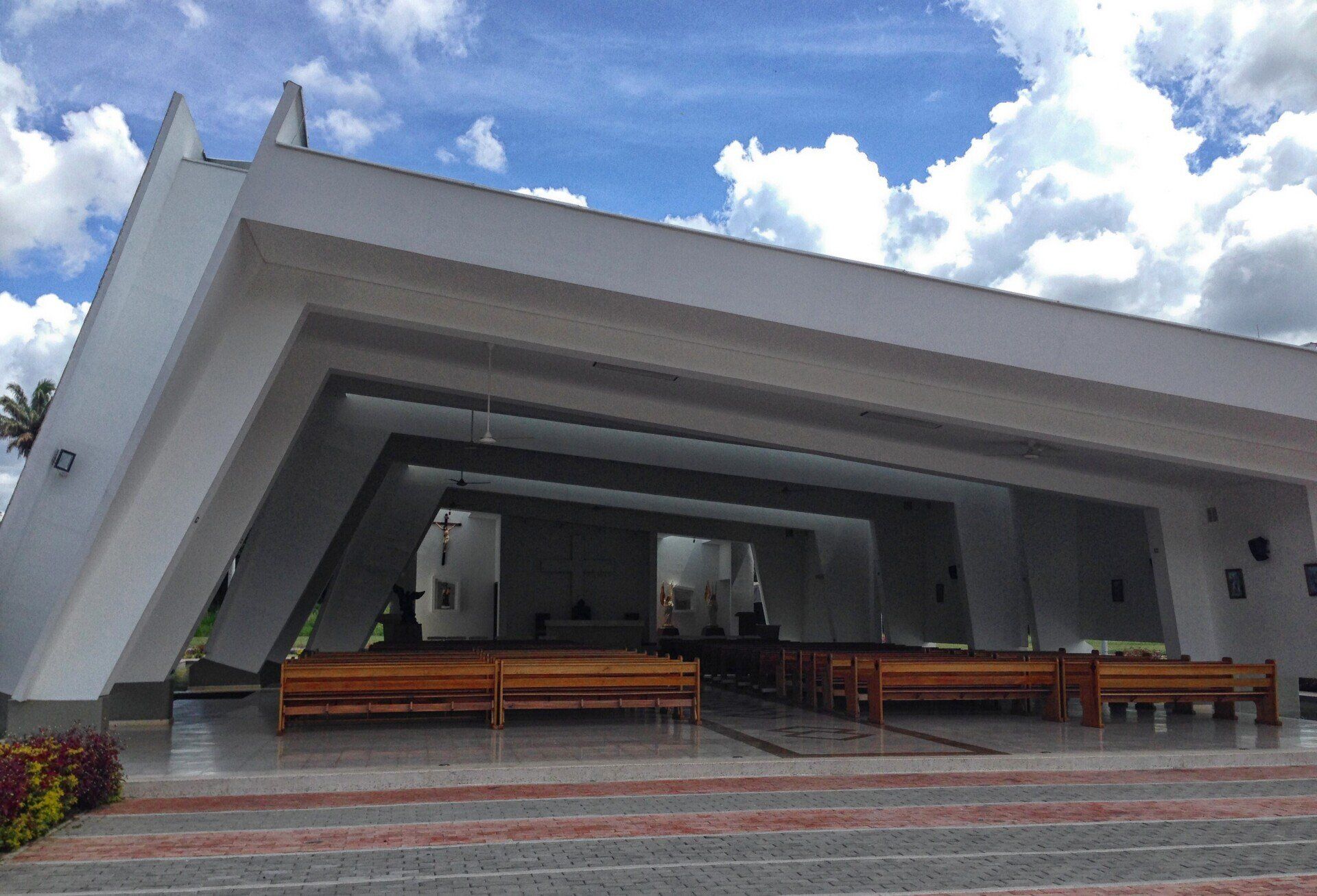 Una iglesia con un cielo azul y nubes detrás
