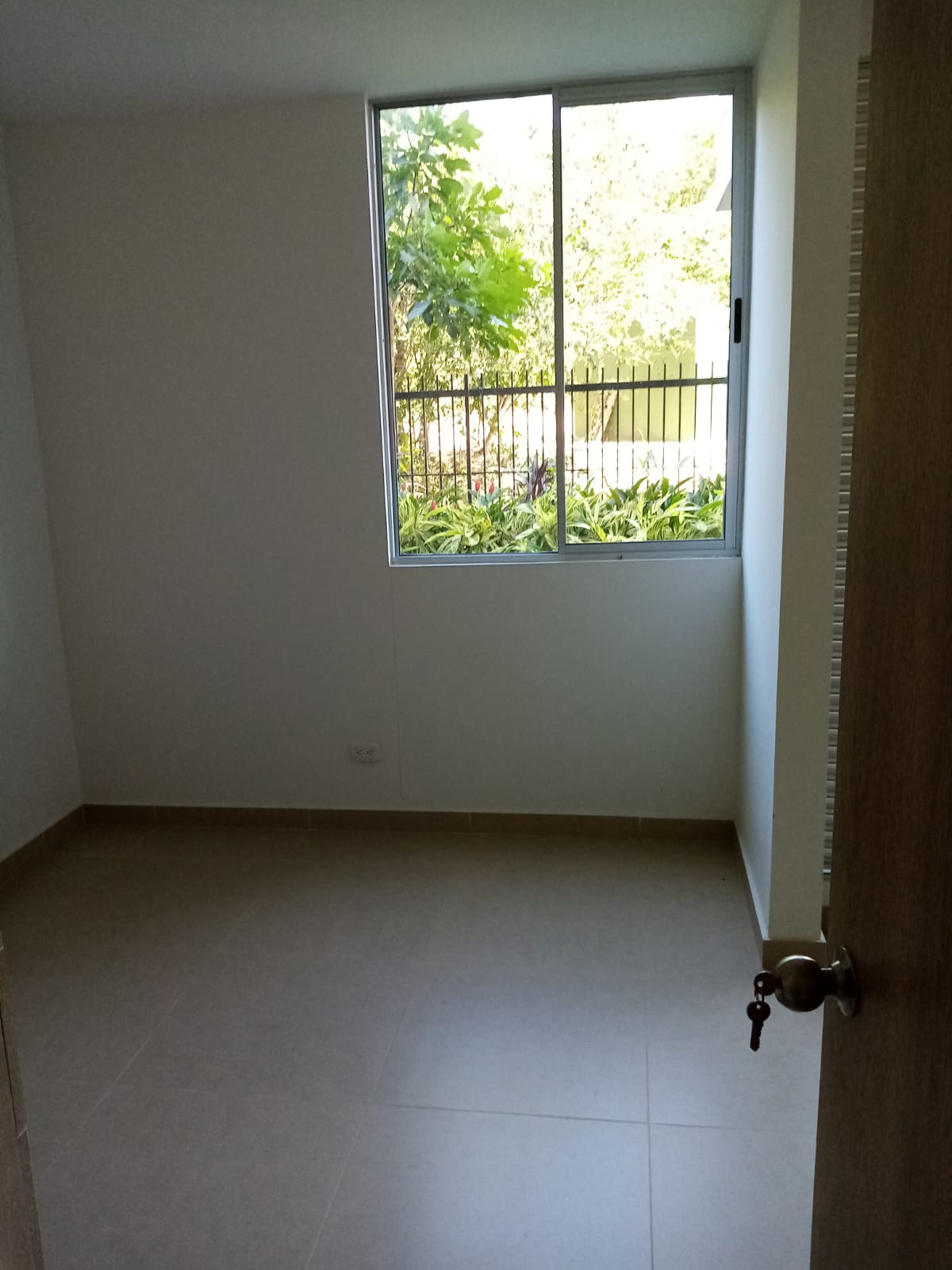 Una habitación vacía con una ventana y una puerta