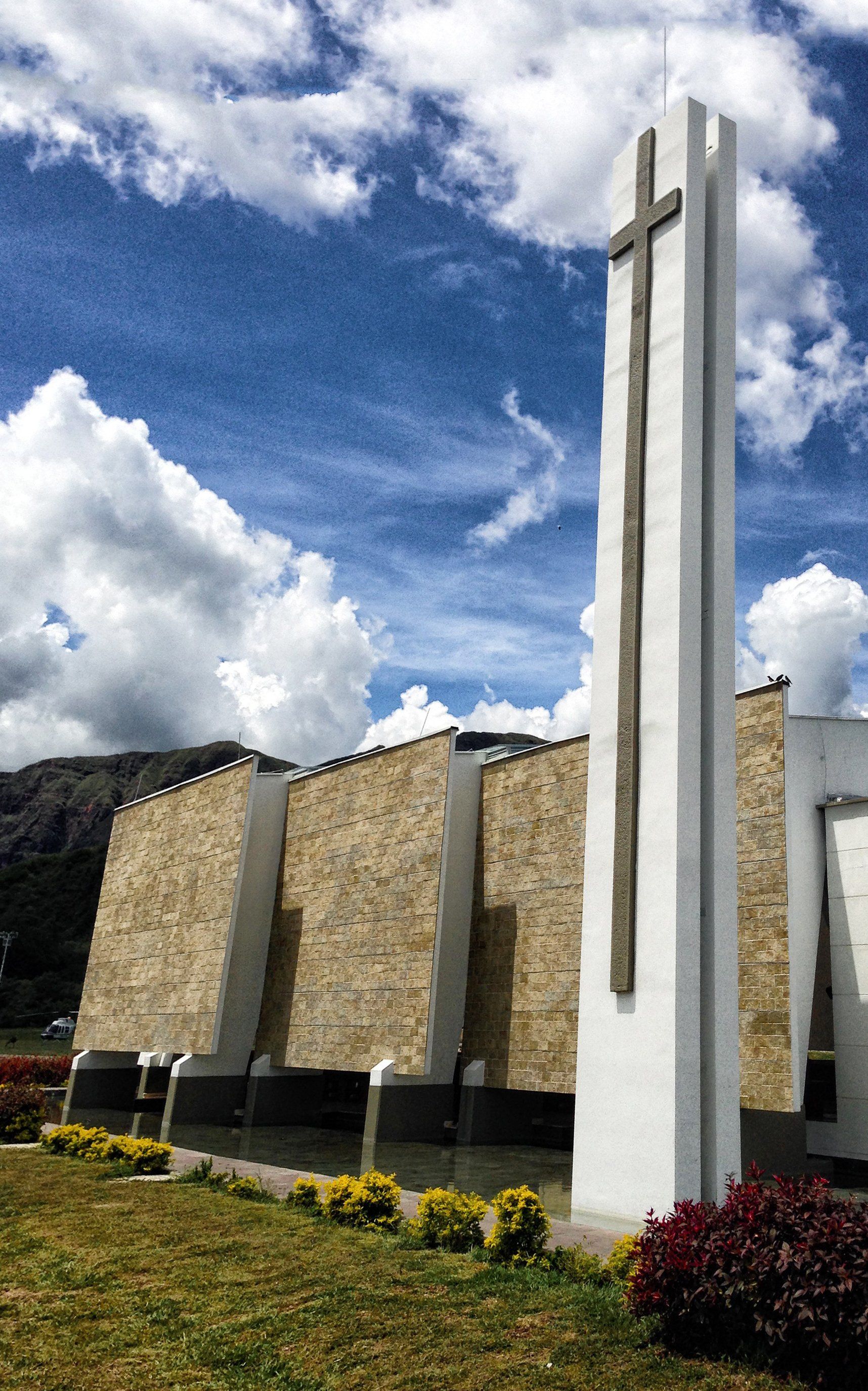 Un gran edificio blanco con una cruz encima