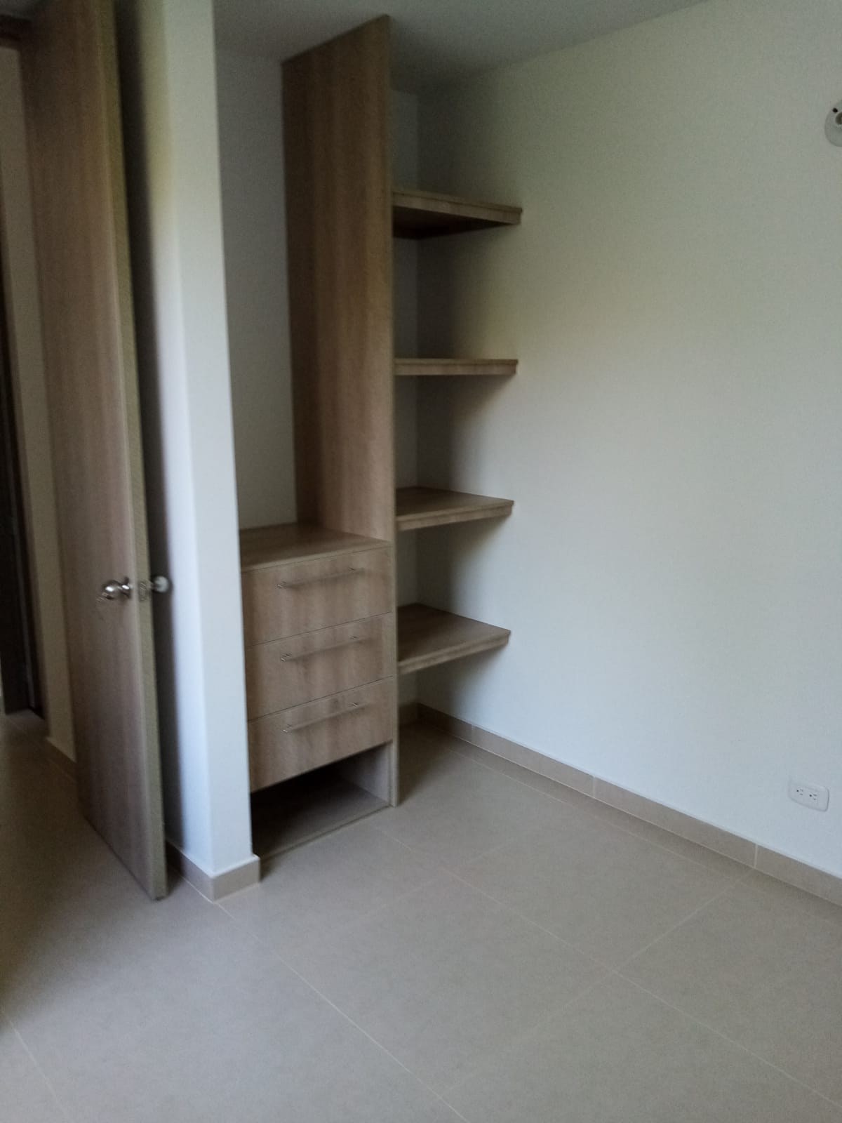 Una habitación con un armario y estantes