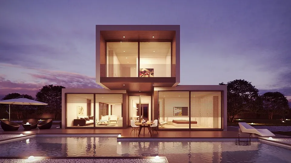 Una casa moderna con piscina en el patio trasero por la noche.