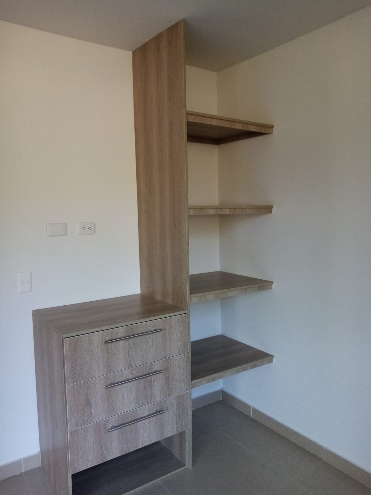 Una habitación con una cómoda y estantes